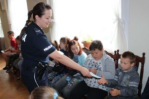 policjantka rozdaje dzieciom ulotki