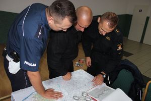 policjant ze strażakami ogląda mapę
