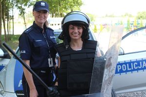 policjantka przy radiowozie z wychowawczynią w stroju szturmowym