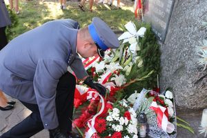 policjant składa kwiaty pod pomnikiem