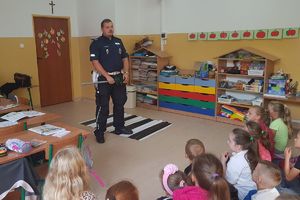 policjant objaśnia dzieciom sygnały drogowe