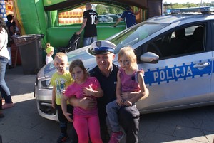 policjant ruchu drogowego na tle radiowozu z 3 dzieci