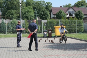policjanci przyglądają się jeździe dziewczyny na rowerze