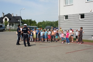 policjanci z dziećmi przed budynkiem komendy policji