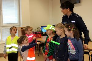 policjantka z dziećmi w odblaskowych elementach