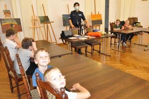 dzieci siedzą na krzesłach w sali podczas prelekcji policjantki z KPP w Lipnie